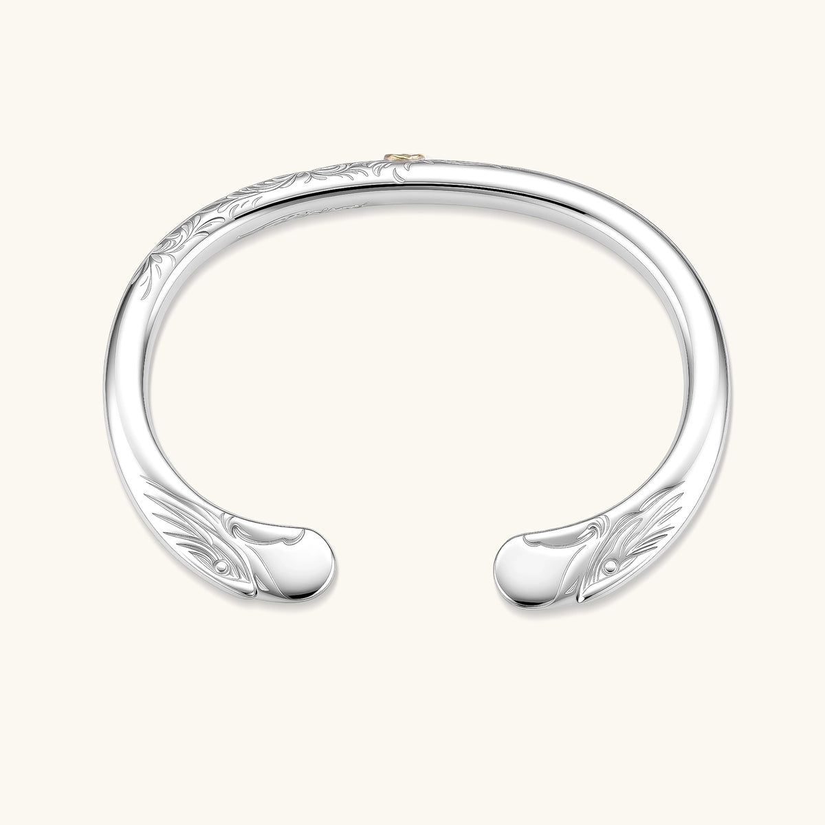 Sterling silver open cuff bracelet with scroll engravings, gold central medallion, and eagle-head terminals. 78mm outer diameter.