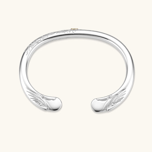 Sterling silver open cuff bracelet with scroll engravings, gold central medallion, and eagle-head terminals. 78mm outer diameter.