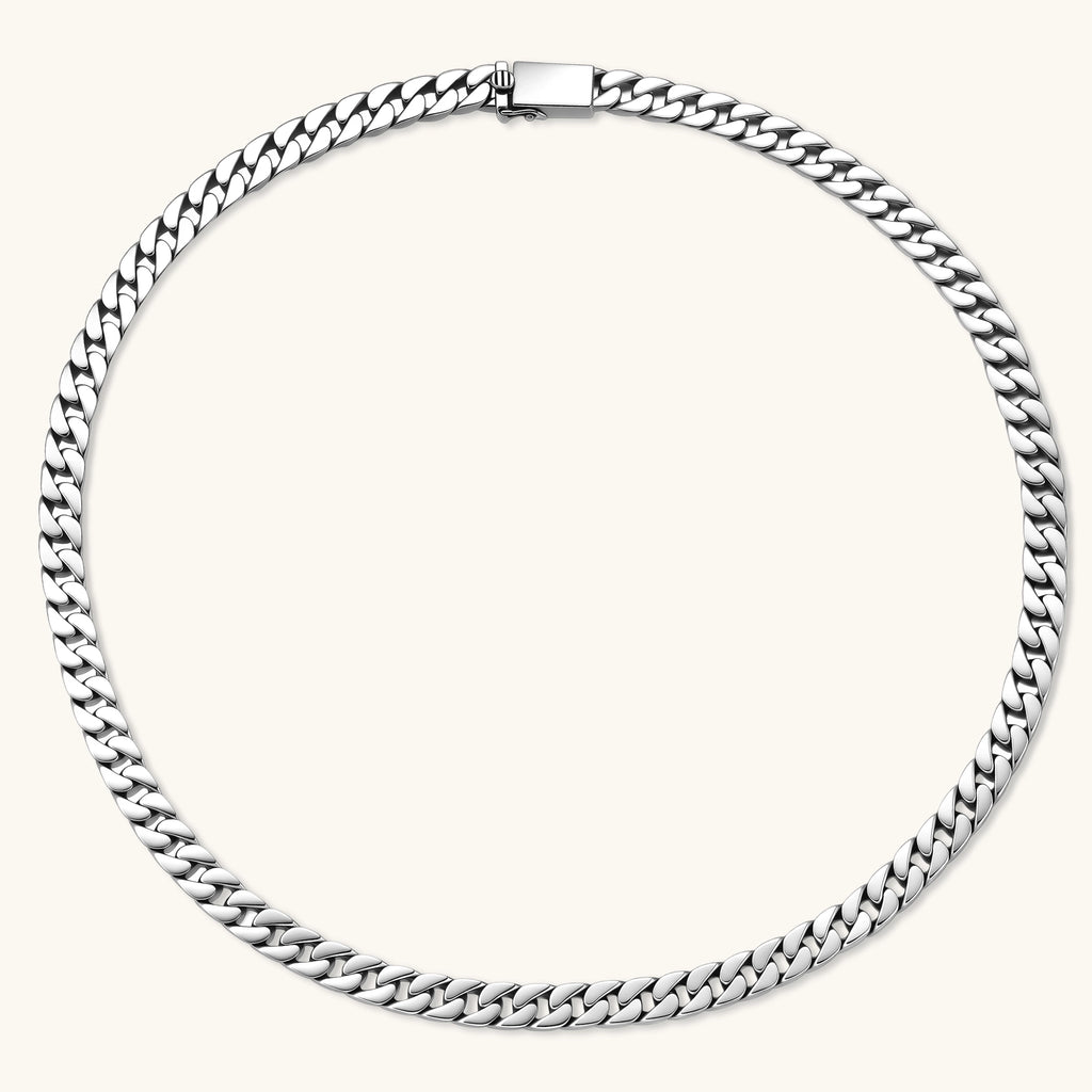 Polished 925 sterling silver Cuban link chain necklace, 550mm length, shown flat and draped on cream background.