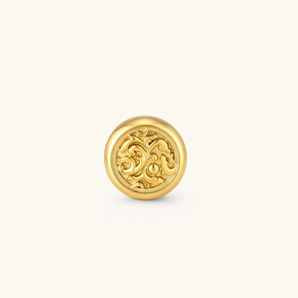 Side view of a round gold stud earring with raised baroque scroll engraving, domed border, and butterfly push-back closure.