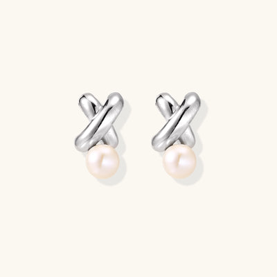 Sterling silver twisted stud earrings with round freshwater pearls on cream background, showing polished finish