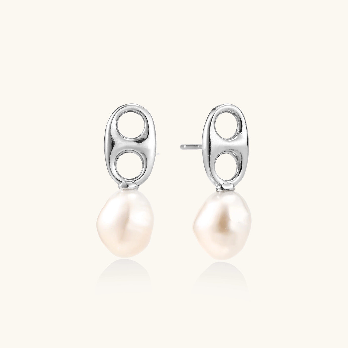 Sterling silver oval stud earrings with dual circular cutouts and suspended freshwater pearls on white background.