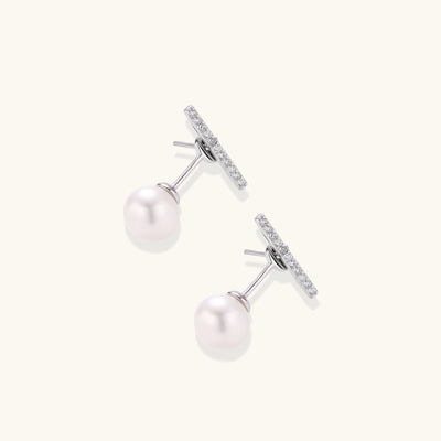 Sterling silver bar stud earrings with freshwater pearl drops on white background, minimalist jewelry design
