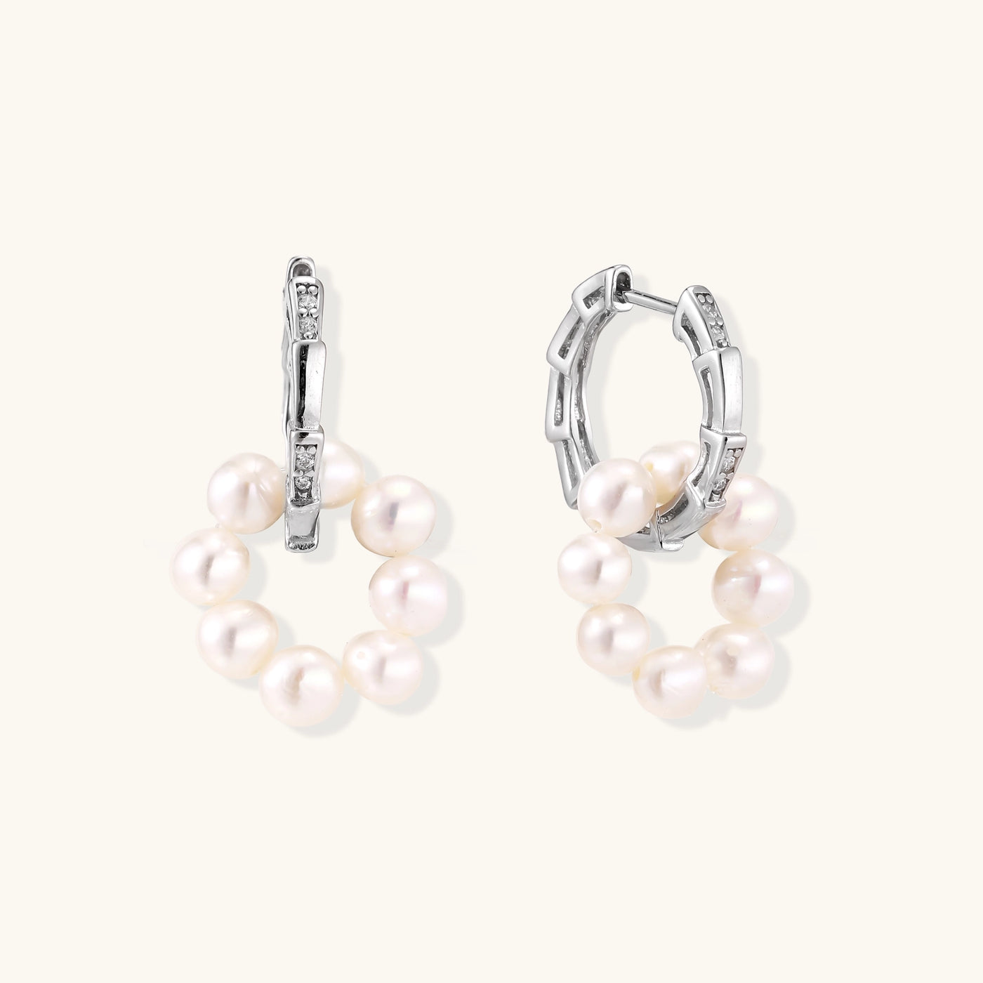 Sterling silver huggie hoop earrings with clustered white freshwater pearls and crystal accents on white background.