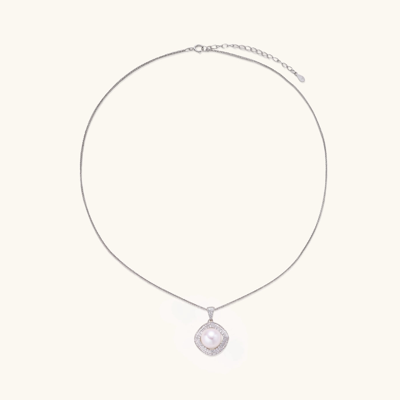 Sterling silver necklace with geometric halo setting surrounding a 10mm freshwater pearl on white background.
