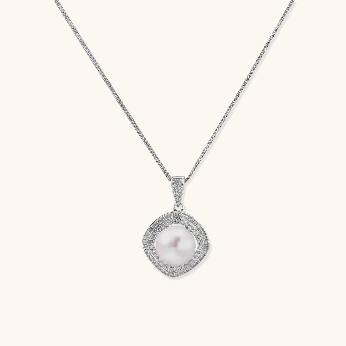 Sterling silver necklace with geometric halo setting surrounding a 10mm freshwater pearl on white background.