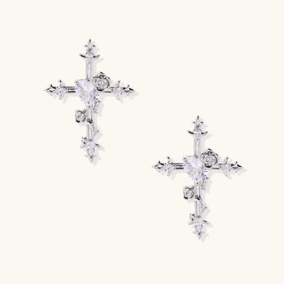 Ornate cross-shaped dangle earrings with gold roses and sparkling zirconia stars on silver-toned base with hoop closures.