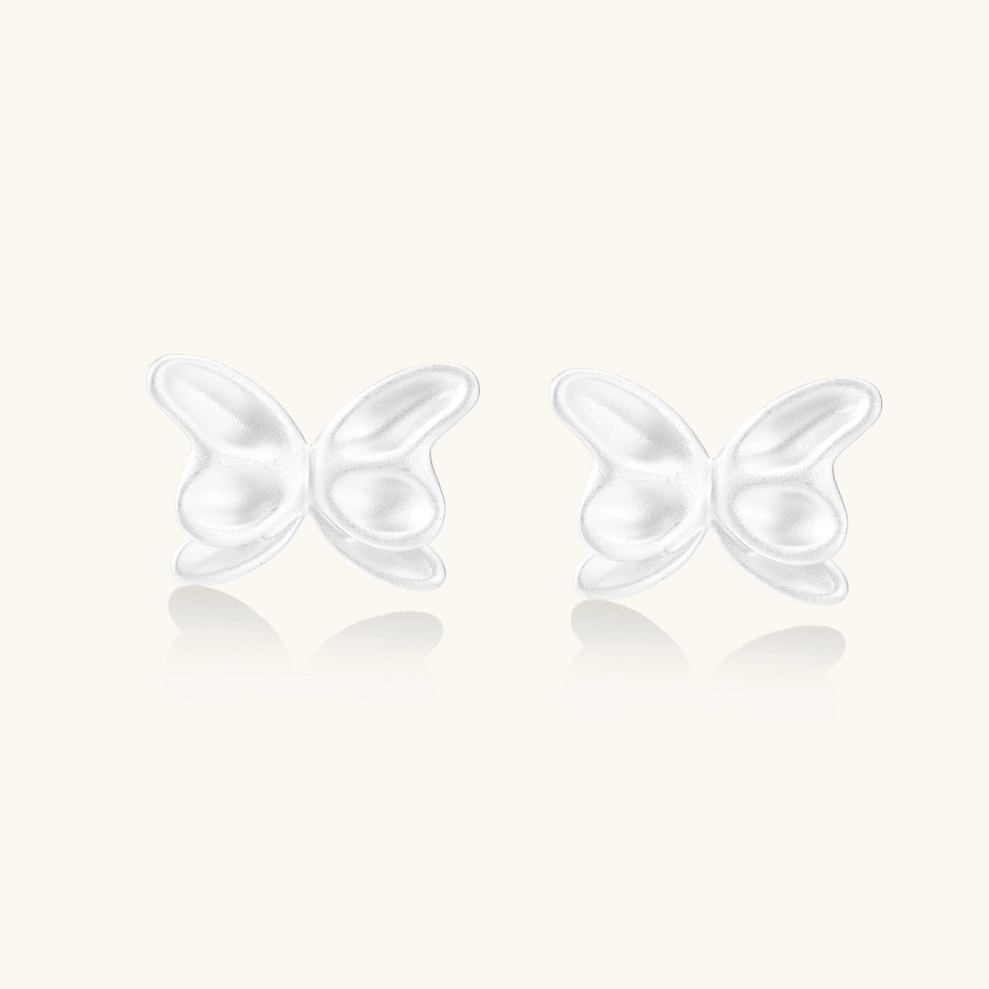 Delicate sterling silver butterfly stud earrings with intricate wing details on a neutral background.