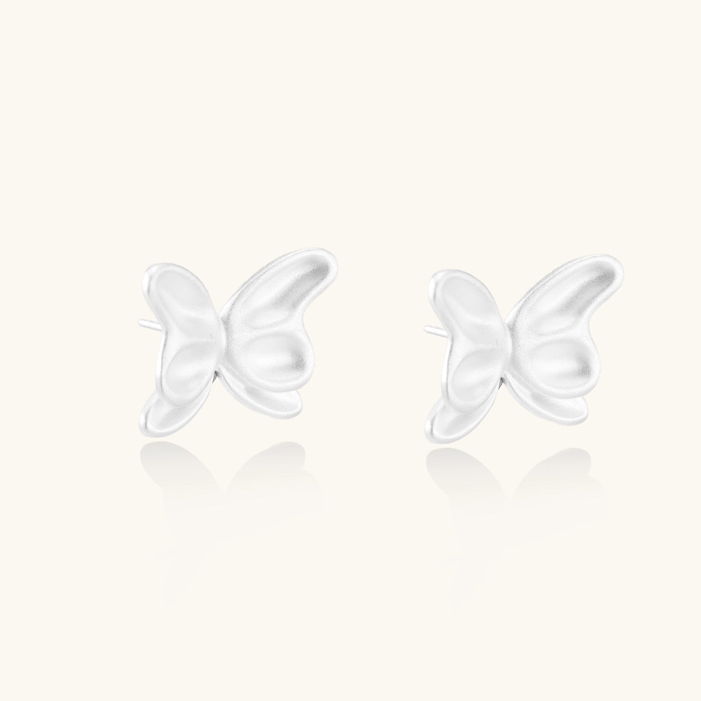 Delicate sterling silver butterfly stud earrings with intricate wing details on a neutral background.