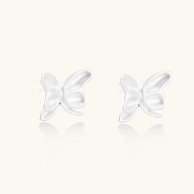 Delicate sterling silver butterfly stud earrings with intricate wing details on a neutral background.