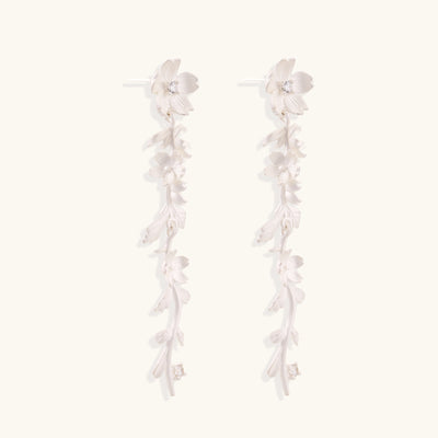 Pair of sterling silver dangle earrings with intricate leaf vine patterns and crystal accents on white background.