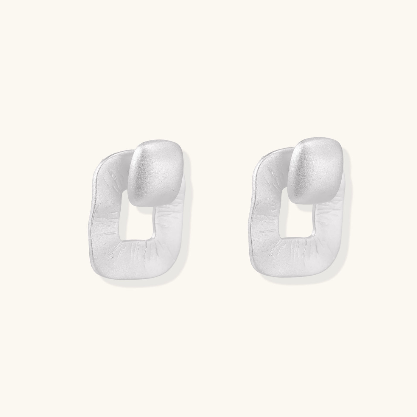 Geometric sterling silver square stud earrings with brushed texture and central square cutouts on white background.