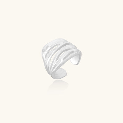 Wide sterling silver ring with flowing wave patterns and adjustable cuff design on white background.