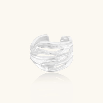 Wide sterling silver ring with flowing wave patterns and adjustable cuff design on white background.
