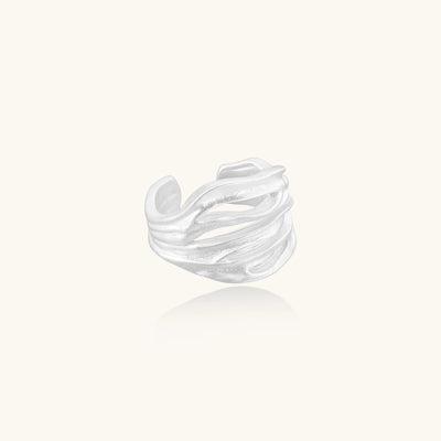 Wide sterling silver ring with flowing wave patterns and adjustable cuff design on white background.