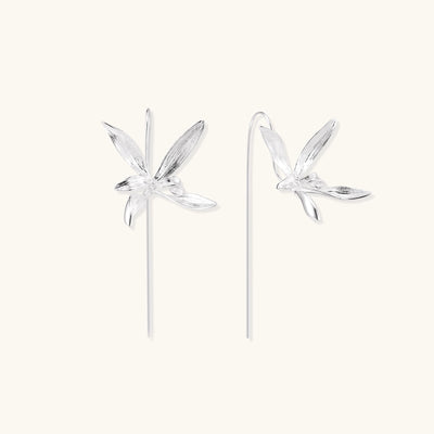 Delicate sterling silver flower earrings with long threader posts and five-petal design on white background.