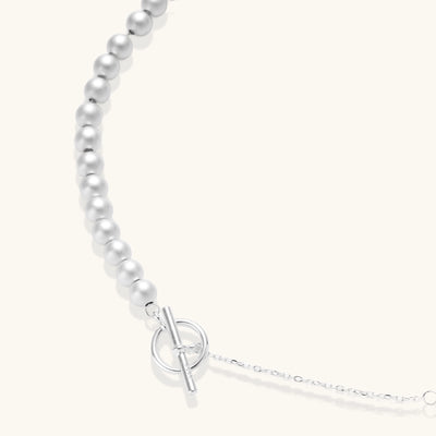 Sterling silver necklace with graduated pearl beads and delicate chain sections featuring a toggle clasp closure.