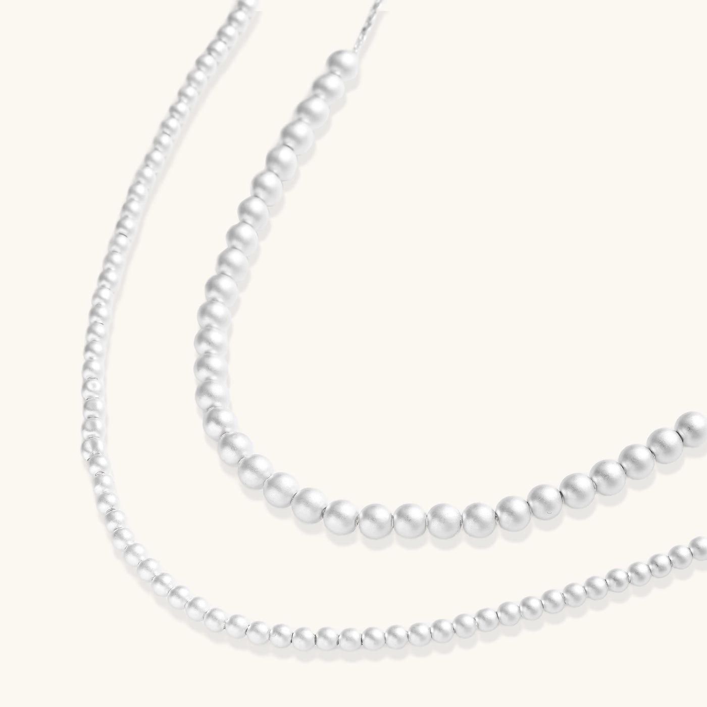 Sterling silver necklace with graduated pearl beads and delicate chain sections featuring a toggle clasp closure.
