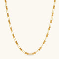 Gold-plated sterling silver chain necklace with alternating love-knot links and elongated oval links, lobster clasp closure.