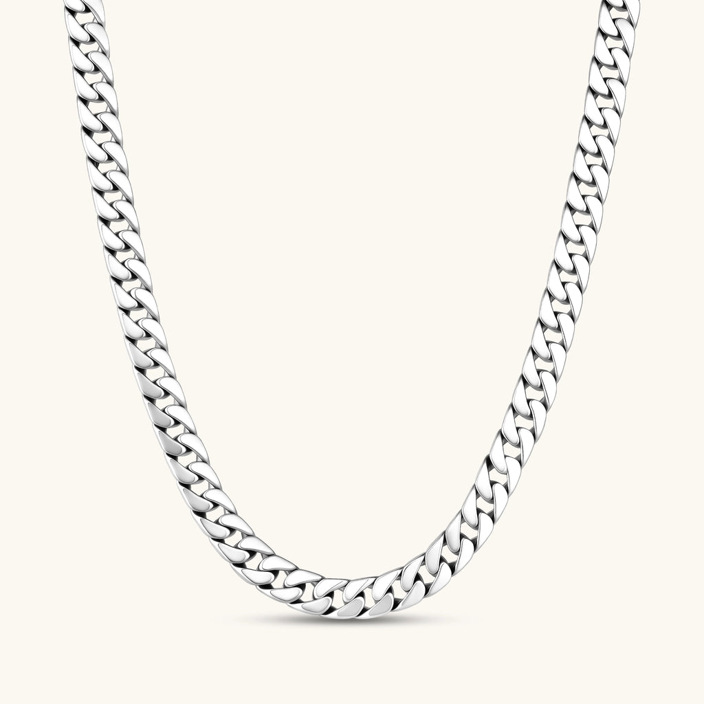 Polished 925 sterling silver Cuban link chain necklace, 550mm length, shown flat and draped on cream background.
