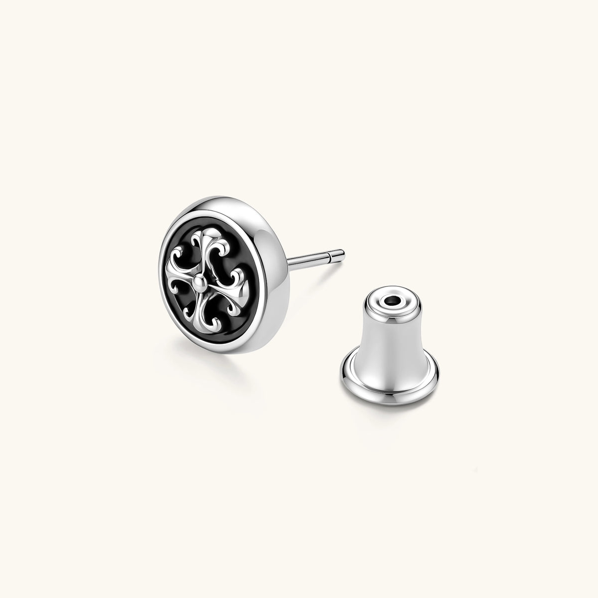 Round sterling silver stud earring with black enamel background and fleur-de-lis cross motif, butterfly push-back closure.