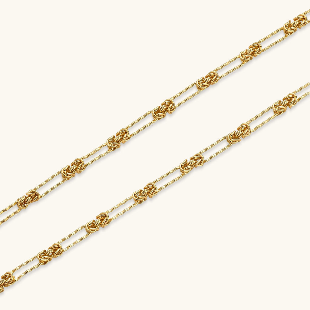 Gold-plated sterling silver chain necklace with alternating love-knot links and elongated oval links, lobster clasp closure.