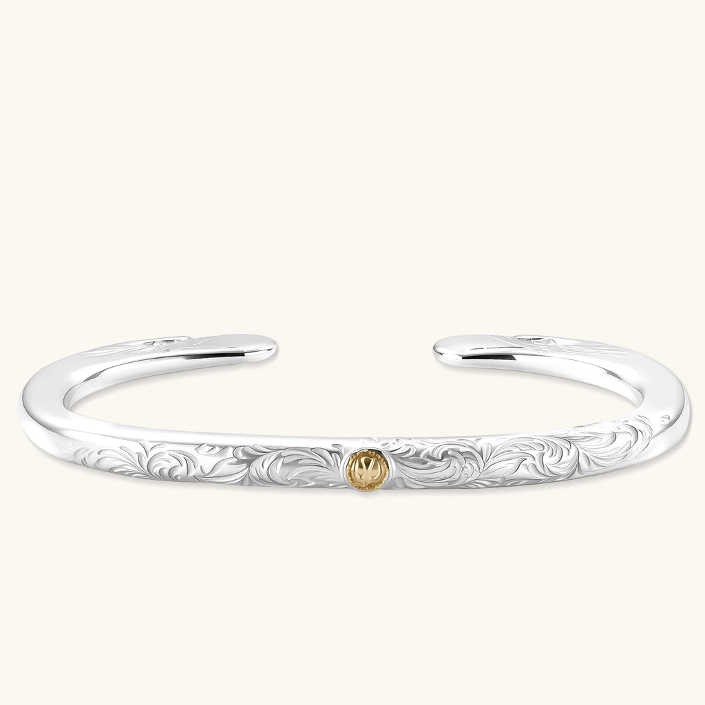 Sterling silver open cuff bracelet with scroll engravings, gold central medallion, and eagle-head terminals. 78mm outer diameter.