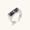 925 sterling silver open signet ring with rectangular black enamel face and raised silver sun-spider motif, adjustable band.