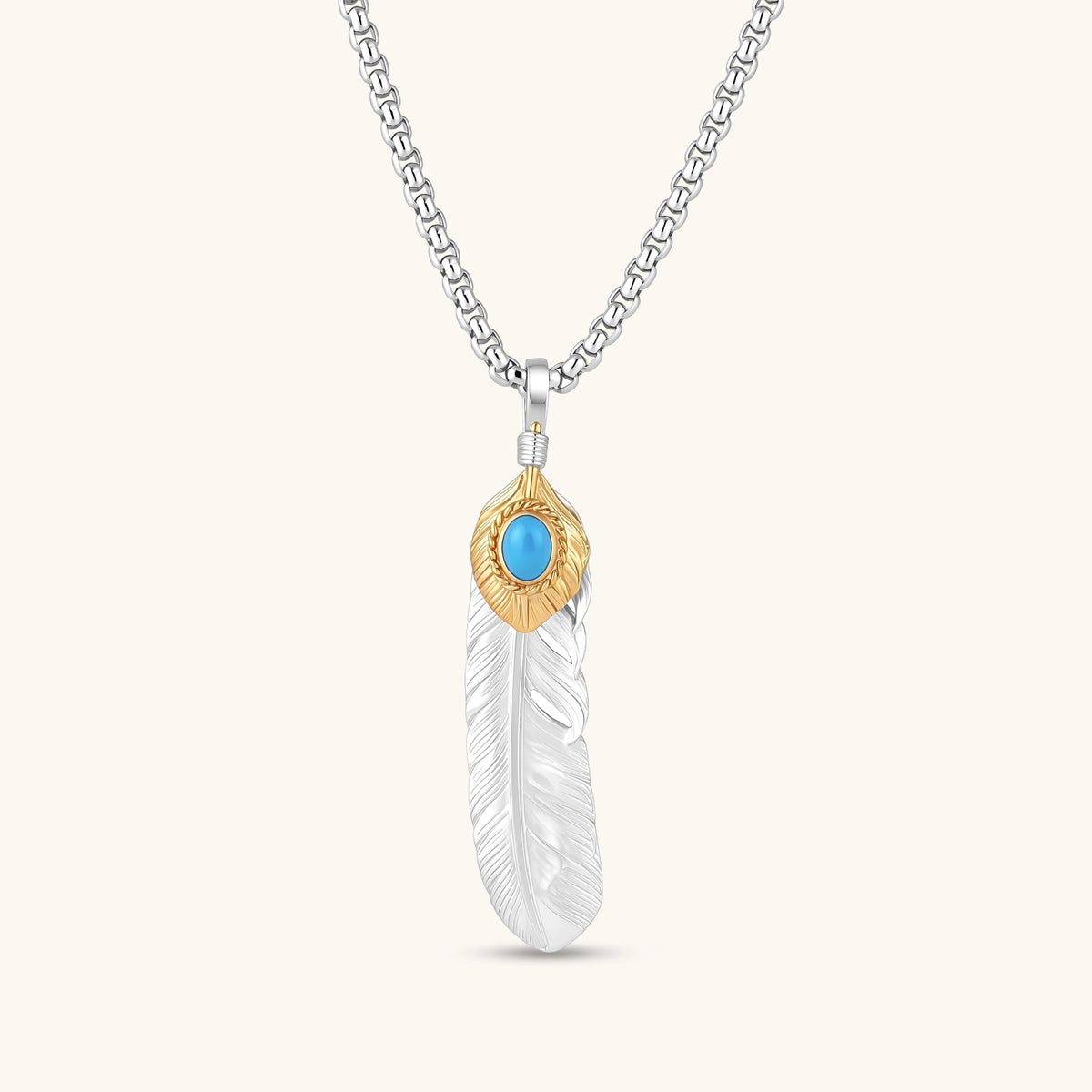 Sterling silver feather pendant with a gold-tone leaf accent and oval blue stone, shown on a box chain against a cream background.