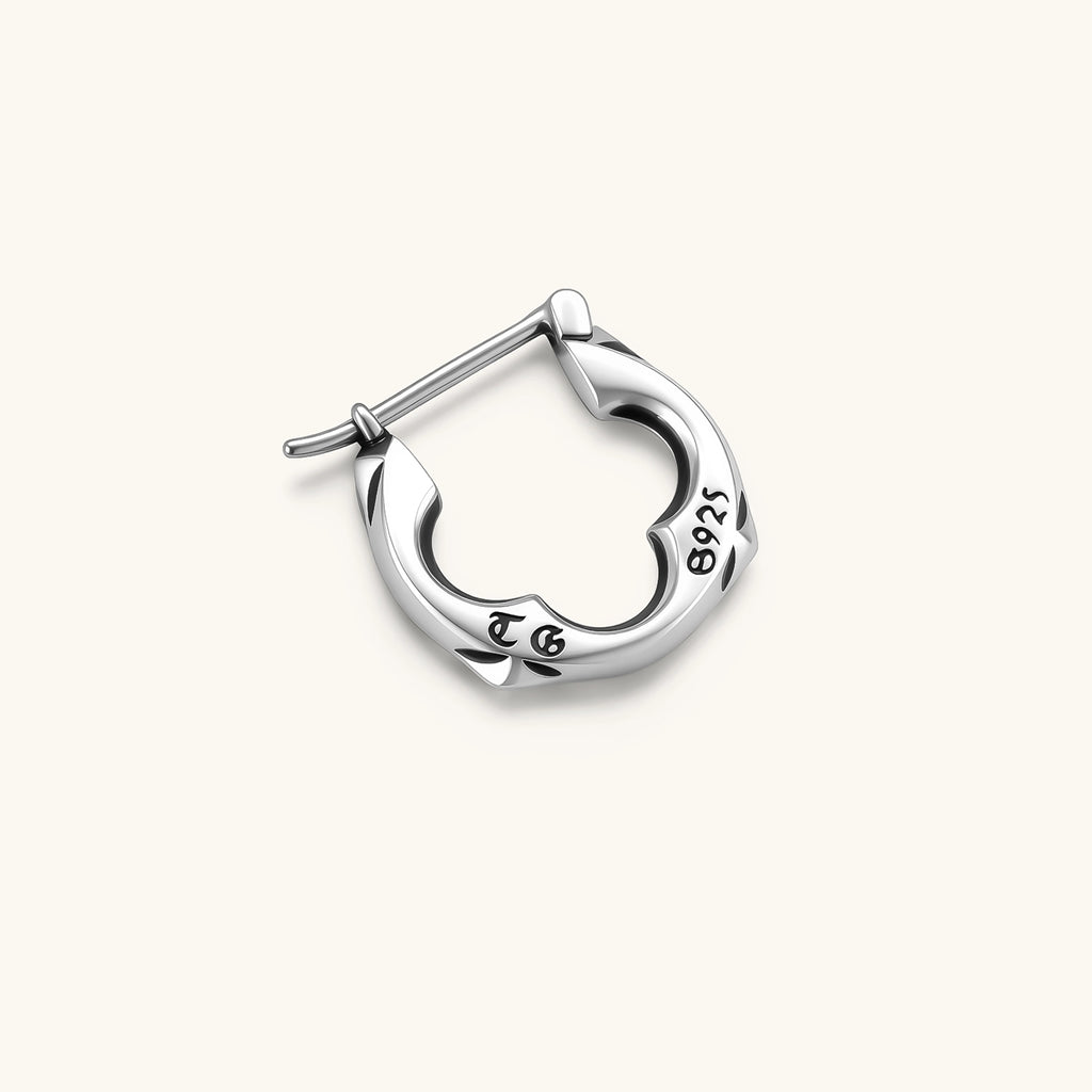 Polished 925 sterling silver quatrefoil hoop earrings with hinged snap closure and engraved hallmark, on cream background.
